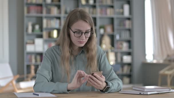 Chockad ung kvinna blir upprörd när du använder smartphone — Stockvideo