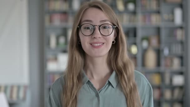 Retrato de mujer alegre sonriendo y saludando a la cámara en la oficina — Vídeos de Stock