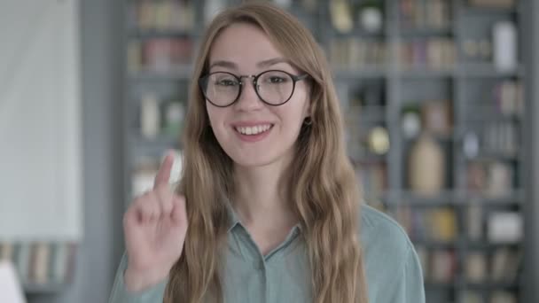 Портрет веселої молодої жінки, яка вказує пальцем на камеру — стокове відео