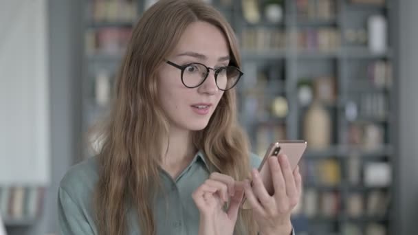 Portret van succesvolle jonge vrouw vieren tijdens het gebruik van Smartphone — Stockvideo