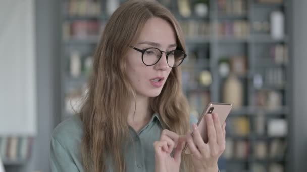 Porträtt av chockad ung kvinna blir upprörd när du använder smartphone — Stockvideo