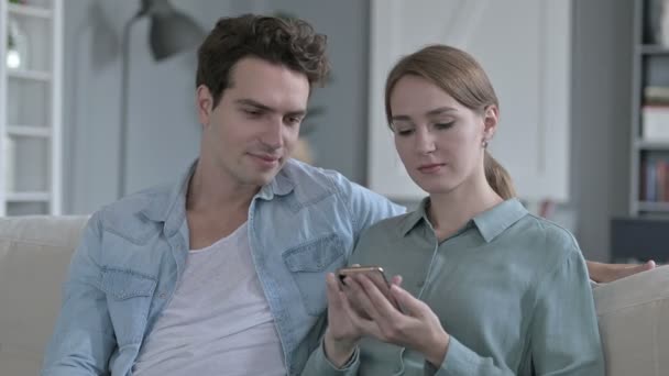 スマートフォンを使用している間、陽気なカップルの肖像画 — ストック動画