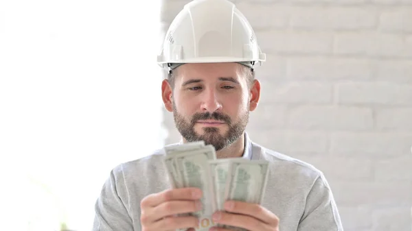 Retrato de ambicioso joven ingeniero contando dólares — Foto de Stock