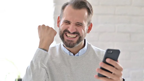 Portrait of Young Man Celebrating Success on Smartphone — Stock Photo, Image