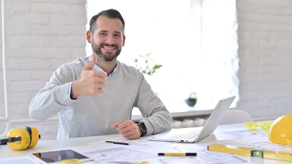 Un jeune architecte positif fait les pouces au bureau — Photo