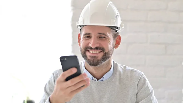 Porträt eines fröhlichen jungen Ingenieurs mit Smartphone — Stockfoto