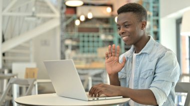 Genç Afrikalı Adam Cafe 'de dizüstü bilgisayarda görüntülü sohbet yapıyor.