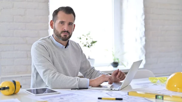 Ung arkitekt med laptop Tittar på Kamera i Office — Stockfoto