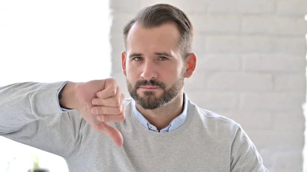 Portret van teleurgestelde jongeman doet duimen naar beneden — Stockfoto