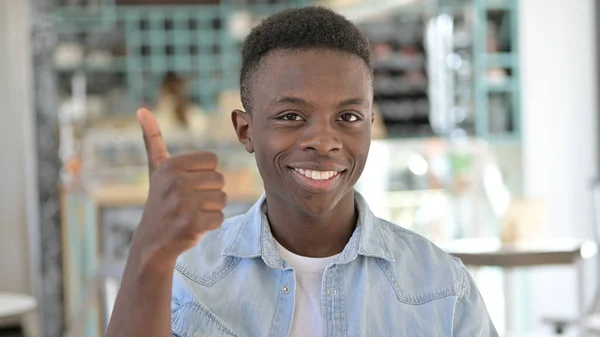 Retrato de positivo jovem africano fazendo polegares para cima — Fotografia de Stock