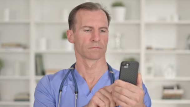 スマートフォンを用いた集中型中高年医師の肖像 — ストック動画