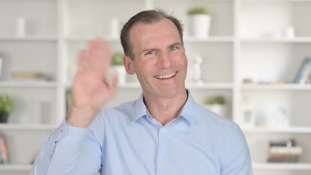 Retrato del hombre de negocios de mediana edad haciendo Video chat y saludando — Vídeos de Stock