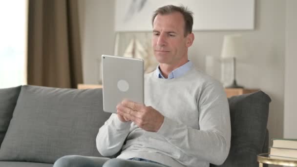 Alegre hombre de negocios de mediana edad usando Tablet en el sofá — Vídeos de Stock