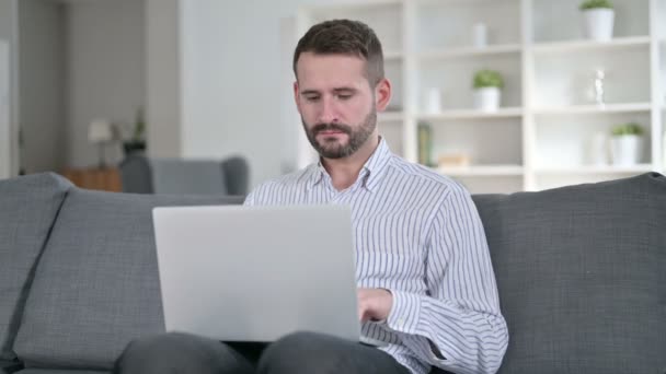 Fokuserad ung man som arbetar på laptop hemma — Stockvideo