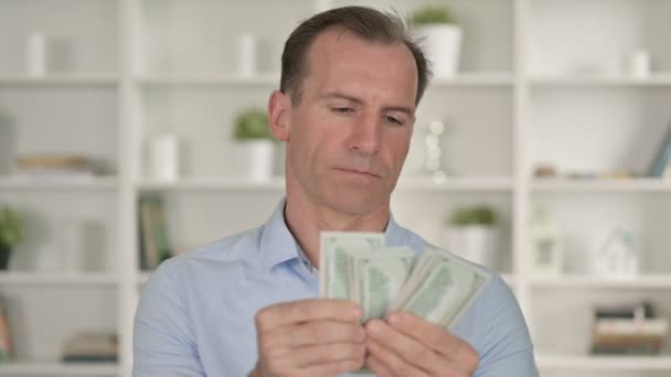 Porträt eines Geschäftsmannes mittleren Alters, der Dollar zählt — Stockvideo