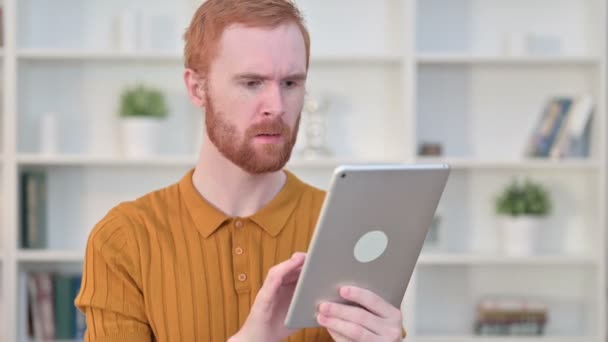 Retrato del hombre pelirrojo reaccionando a la pérdida en la tableta — Vídeo de stock