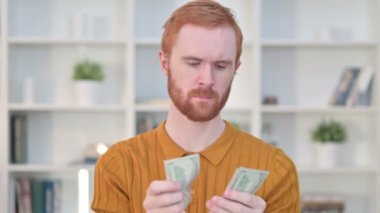 Odaklanmış Kızıl Saçlı Adam 'ın Portresi Dolar Sayıyor 