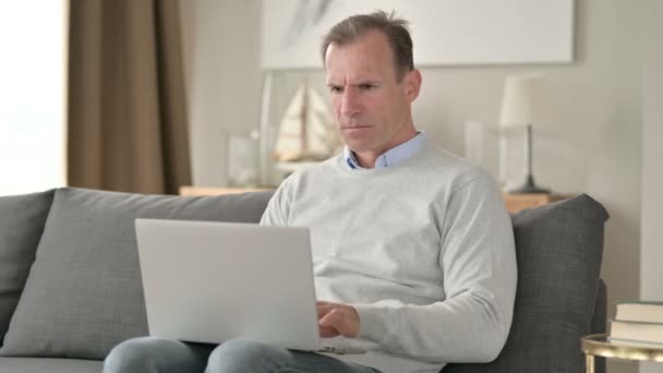 Sorglig medelålders affärsman med förlust på laptop på soffan — Stockvideo
