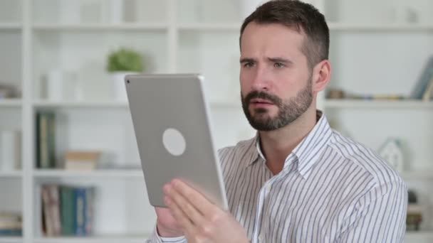A fiatalember arcképe, amint reagál a tablettán lévő veszteségre — Stock videók