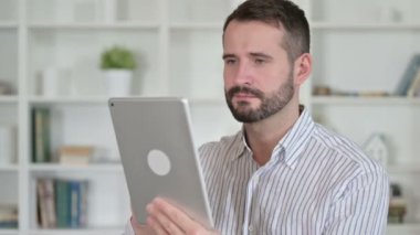 Tablet kullanan hırslı genç adamın portresi.