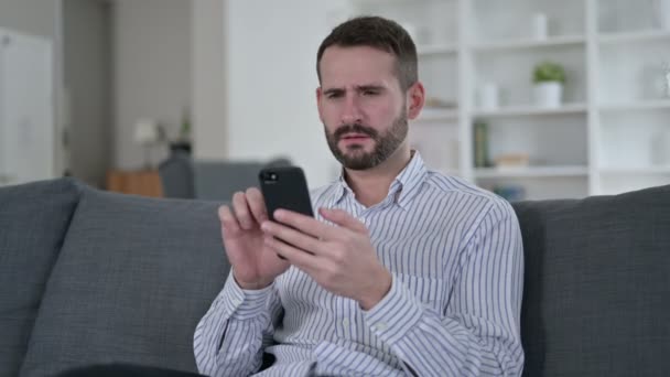 Hombre joven reaccionando al fracaso en el teléfono inteligente — Vídeos de Stock