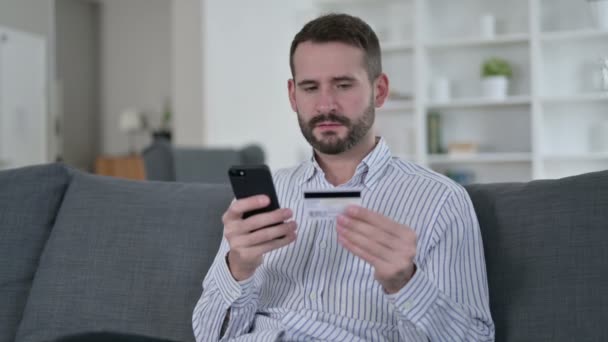 Homem jovem fazendo pagamento on-line em Smartphone em casa — Vídeo de Stock