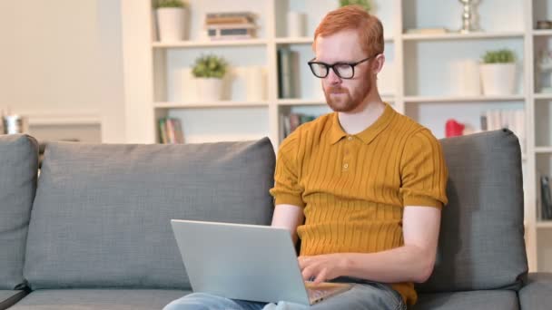 Laptop 'ta çalışan ve öksüren kızıl saçlı adam. — Stok video