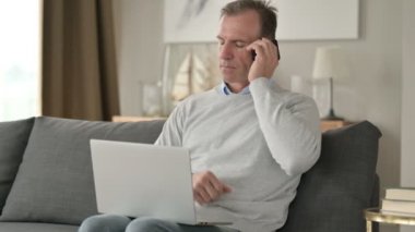Neşeli Orta Çağ İşadamı Kanepede Smartphone 'da konuşuyor