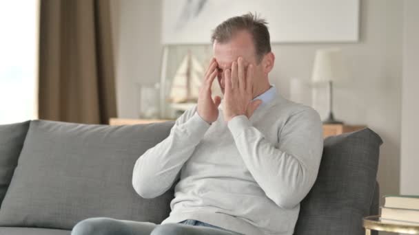 Preocupado hombre de negocios de mediana edad que tiene dolor de cabeza en el sofá — Vídeo de stock