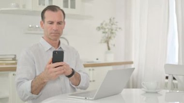 Evde Akıllı Telefon ve Laptop kullanan Profesyonel Orta Çağ Adamı