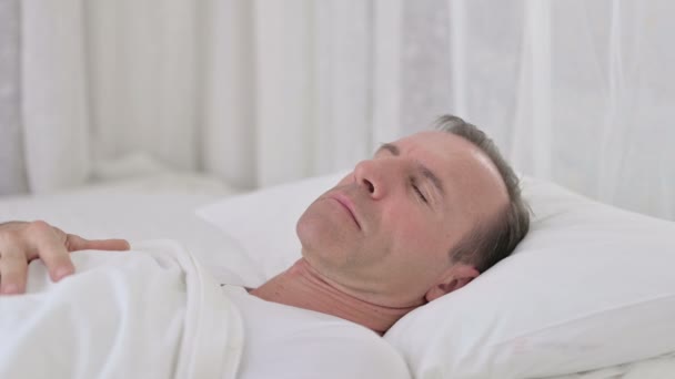 Занепокоєний чоловік середнього віку, який переживає страхіття в ліжку — стокове відео