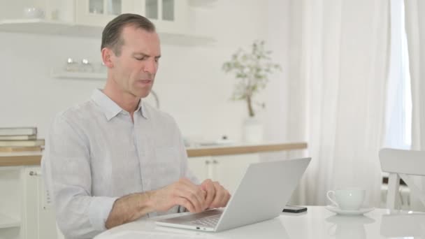 Bărbat de vârstă mijlocie cu laptop care suferă de dureri de spate acasă — Videoclip de stoc