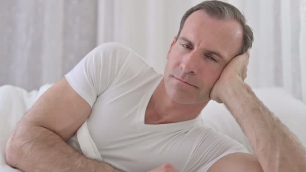 Close-up van vrolijke middelbare leeftijd man glimlachen bij de camera in bed — Stockvideo