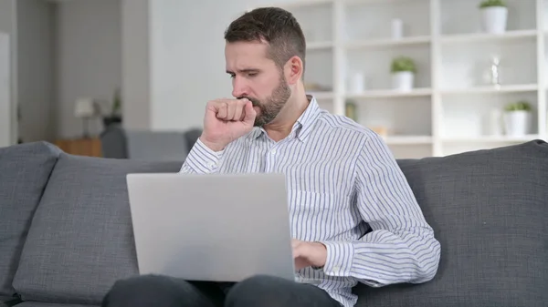 Homem doente trabalhando no laptop e tosse em casa — Fotografia de Stock