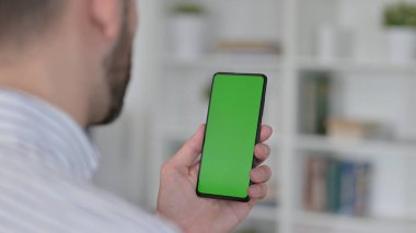 Genç adamın Krom Tuş Ekranı ile Akıllı Telefon kullanışının Arka Görünümü 