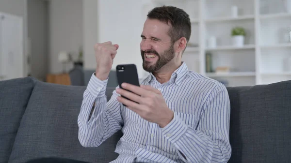 Ambitieuze jongeman viert succes op Smart Phone — Stockfoto
