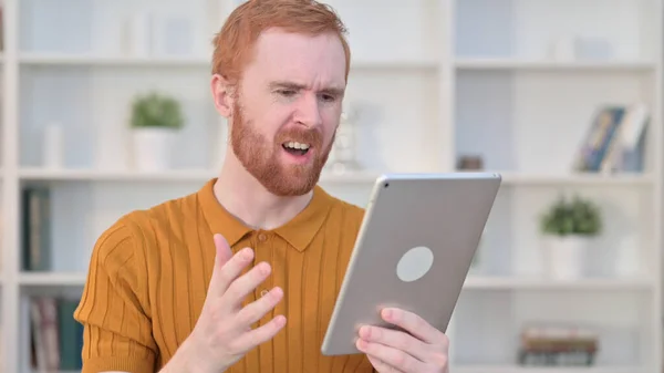 Portret van roodharige man reageert op verlies op tablet — Stockfoto