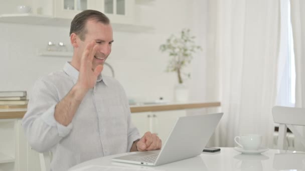 Homem de meia-idade fazendo chamada de vídeo no laptop em casa — Vídeo de Stock