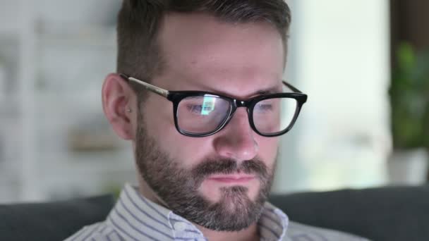 Närbild av Face of Young Man med hjälp av digital enhet hemma — Stockvideo