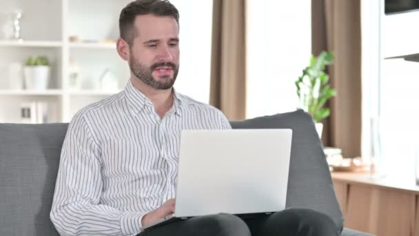 Jovem empresário profissional fazendo chamada de vídeo no laptop em casa — Vídeo de Stock