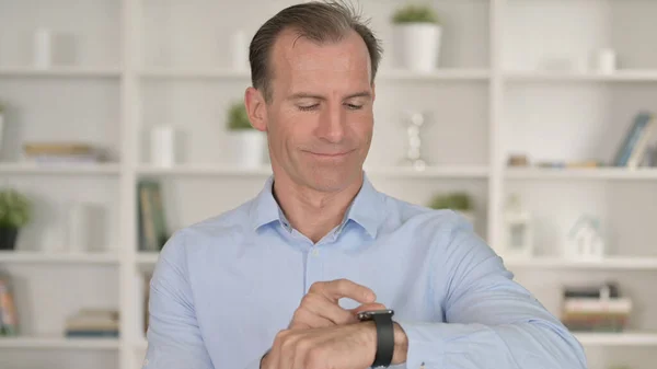 Retrato de hombre de negocios de mediana edad usando reloj inteligente — Foto de Stock