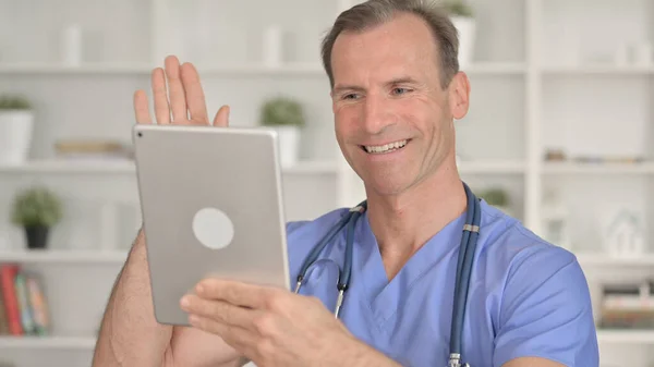 Retrato del médico de mediana edad haciendo Video Chat en Tablet —  Fotos de Stock