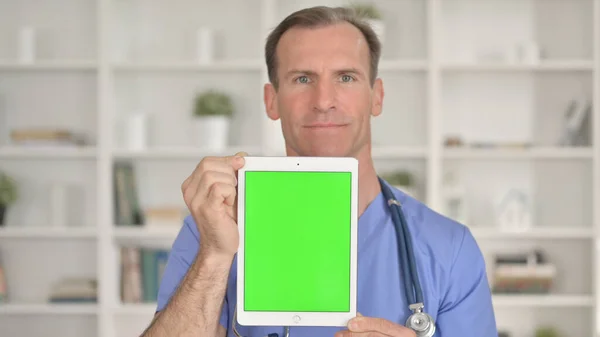 Medelålders läkare håller Tablet med Chroma Key — Stockfoto