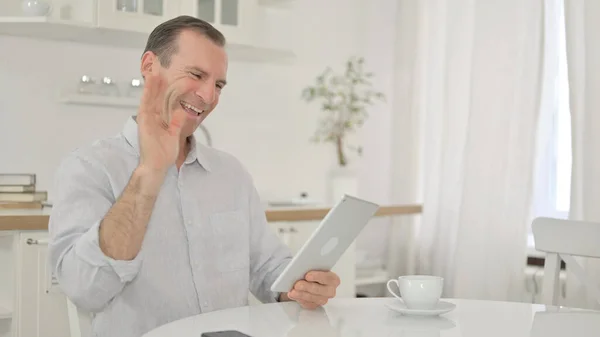 Moyen Age Homme faisant appel à la vidéo sur tablette à la maison — Photo