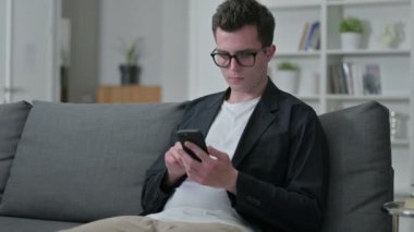 Evde Akıllı Telefon kullanan Genç Erkek Tasarımcı