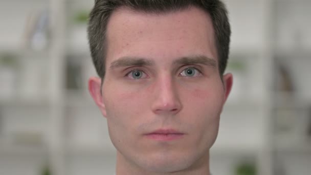 Primer plano de la cara de un joven serio mirando a la cámara — Vídeos de Stock