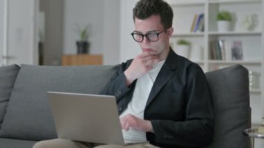 Düşünceli Genç Erkek Tasarımcı Evdeki Laptop 'ta Düşünüyor ve Çalışıyor 