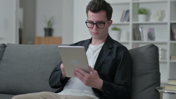 Diseñador masculino joven usando Tablet en casa — Vídeo de stock