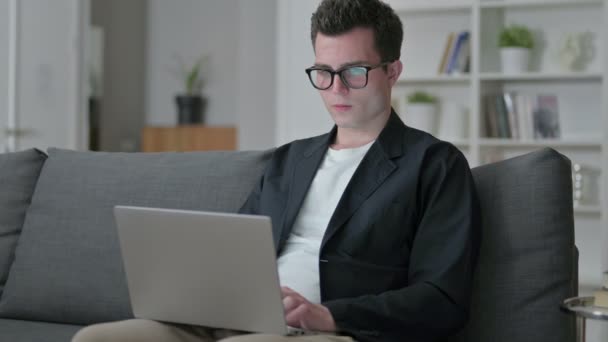 Agotado joven diseñador masculino con el ordenador portátil que tiene dolor de espalda — Vídeo de stock