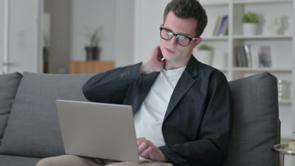 Müder junger männlicher Designer mit Laptop mit Nackenschmerzen zu Hause — Stockvideo